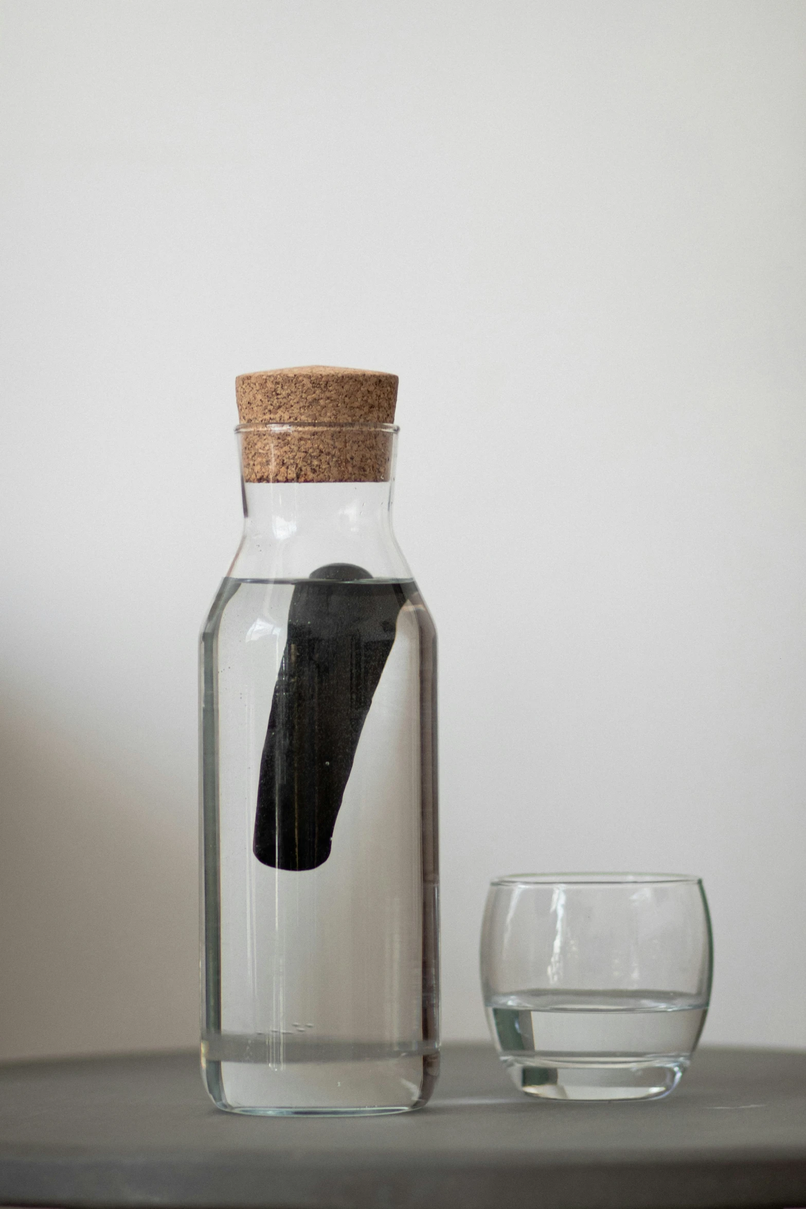 a bottle filled with water and next to it are glass glasses