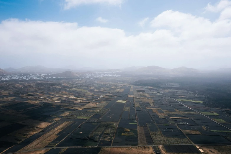 aerial view of countryside with farm land and clouds