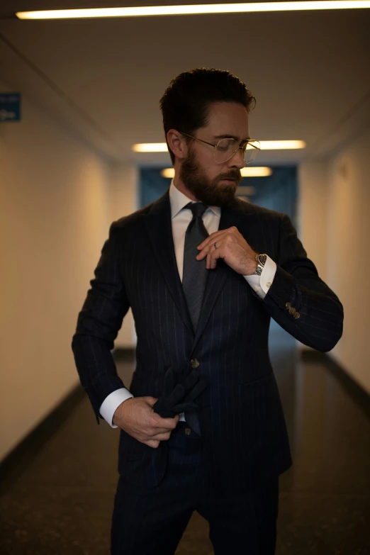 a man in a business suit stands by a hallway