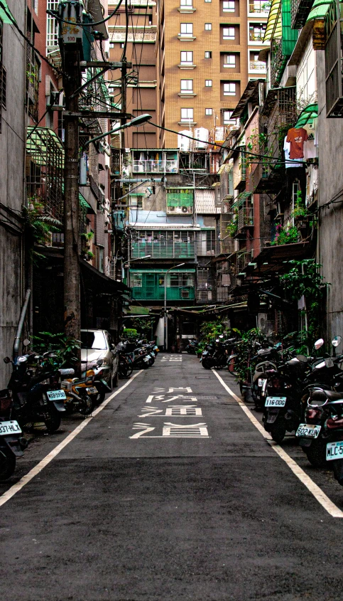 a narrow alley lined with lots of cars and buildings