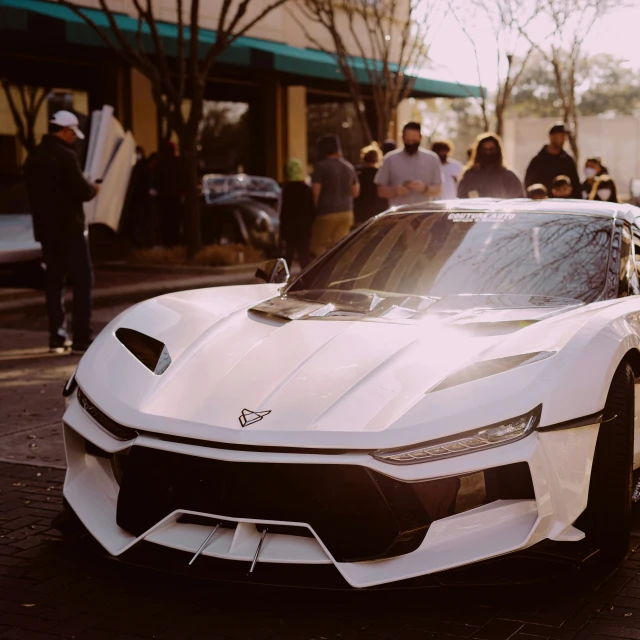 a white sports car parked on the side of the street