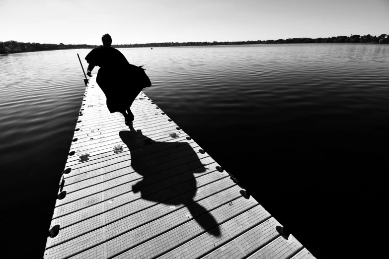 an person walking down a pier near the water