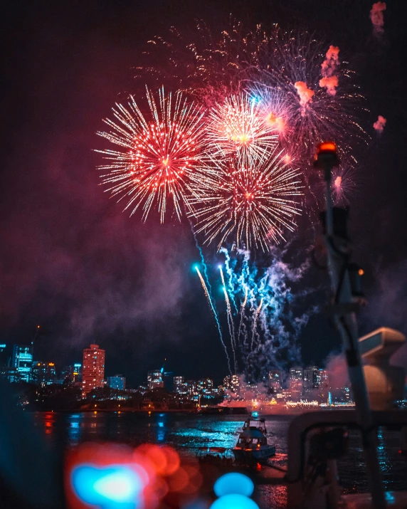 fireworks on a night sky over water and city