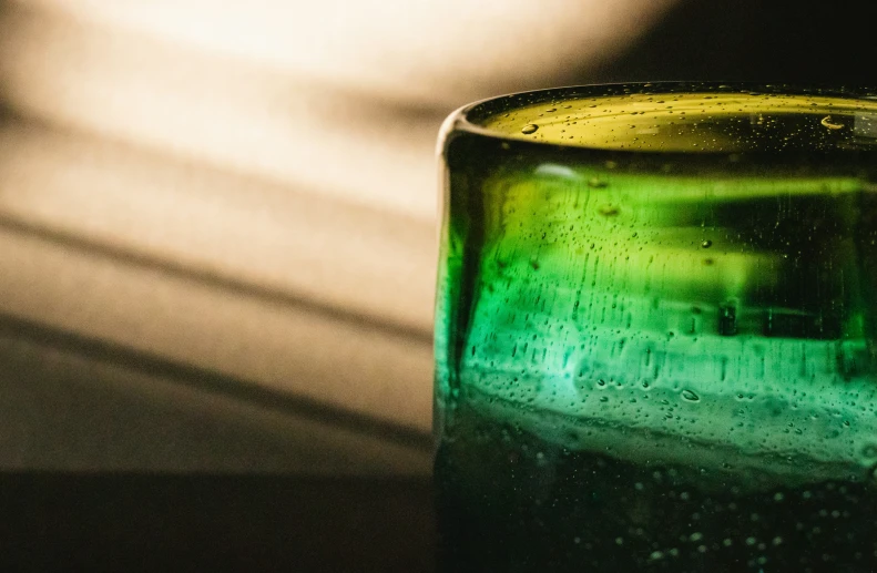 a green glass sitting on top of a counter