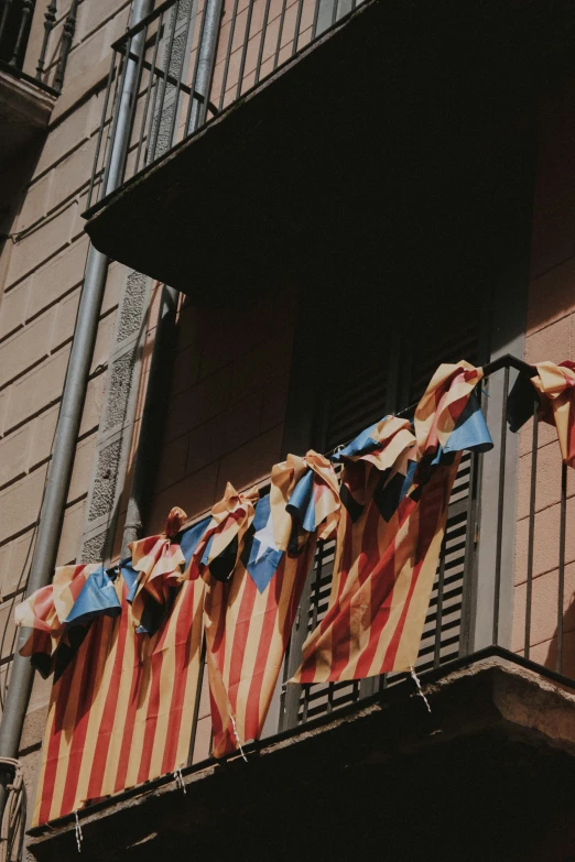 there is a bunch of patriotic flags hung from the balcony