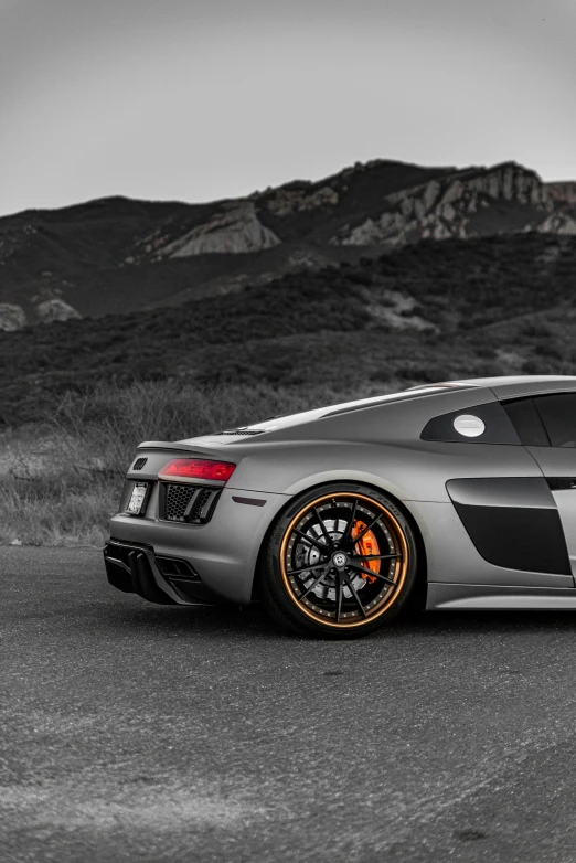 a grey car parked on the road in front of some hills