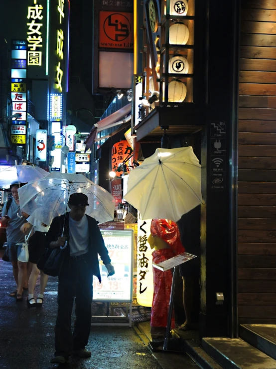 people walk down the street holding umbrellas