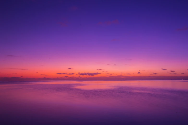 a calm beach as the sun is setting