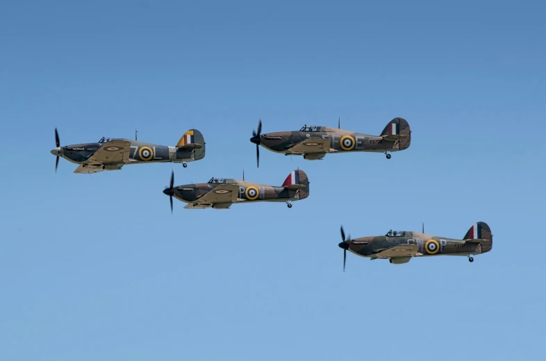 three old time style airplanes fly through the sky