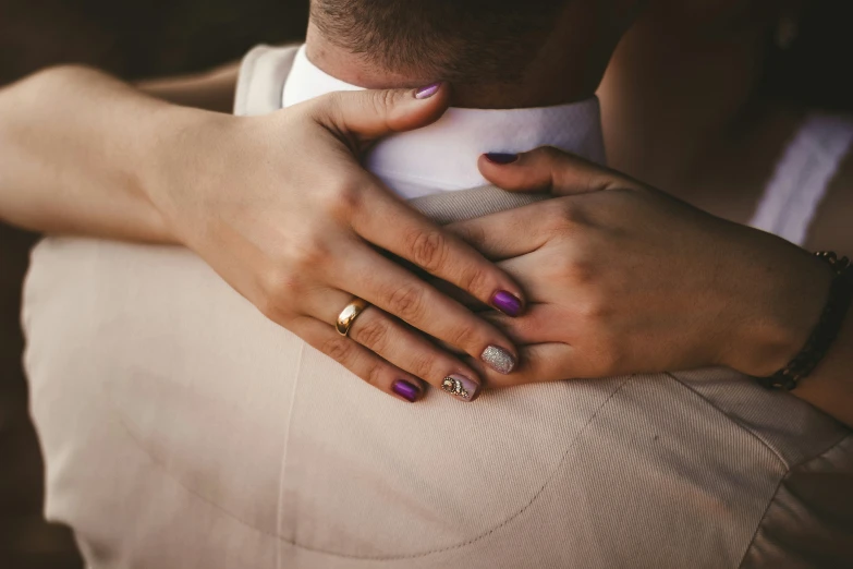 closeup of woman in a vest holding her hand on her chest