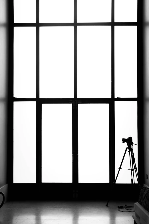 a pographer standing in front of a large window