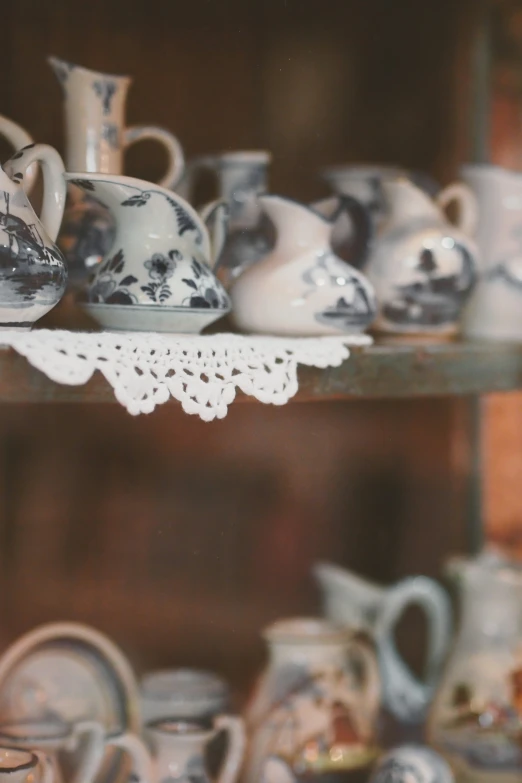 there are many teapots and teacups on a shelf