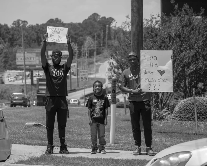 three men holding up signs at a protest