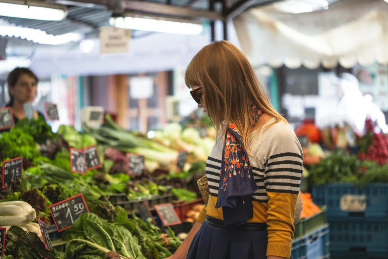 the woman is selecting vegetables from the stand