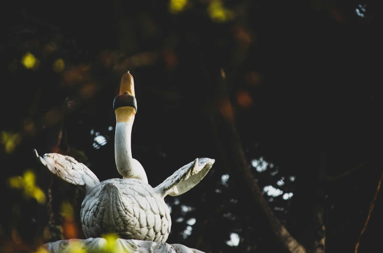 a close up of a bird statue with it's wings extended