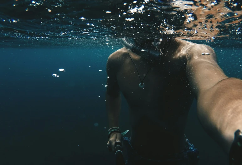 a man with a camera is swimming underwater