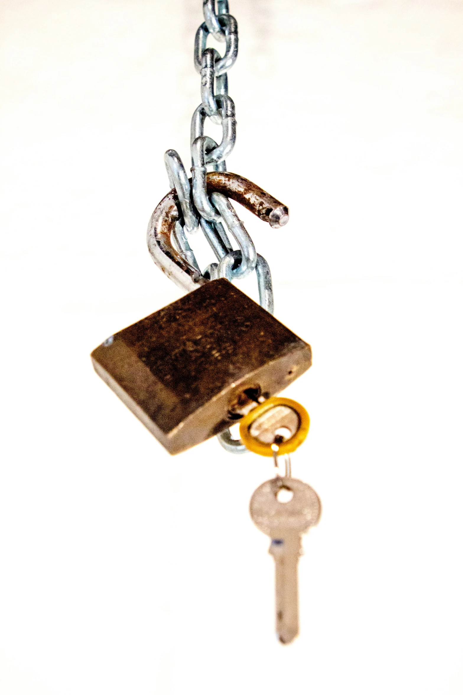 a key is hanging from a chain with a lock