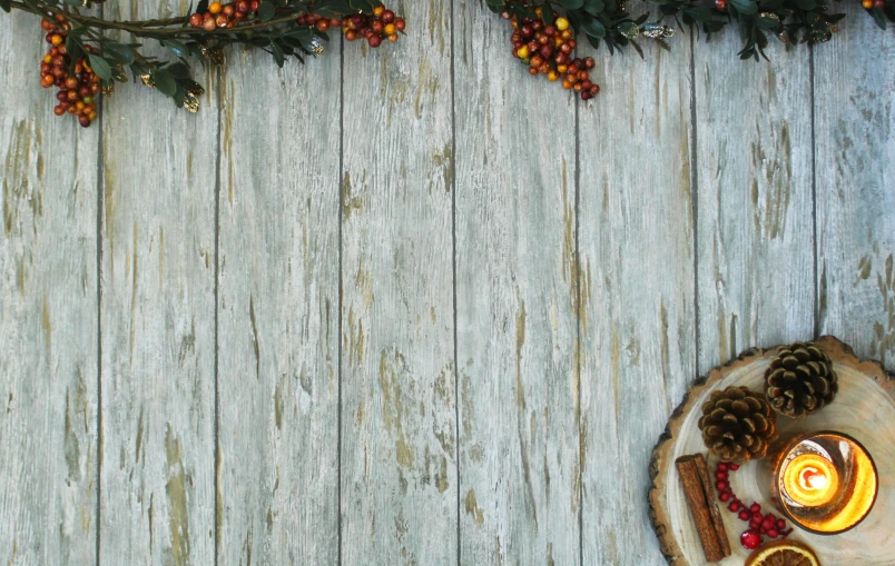 an old wooden wall with pine cones, christmas lights and a coaster