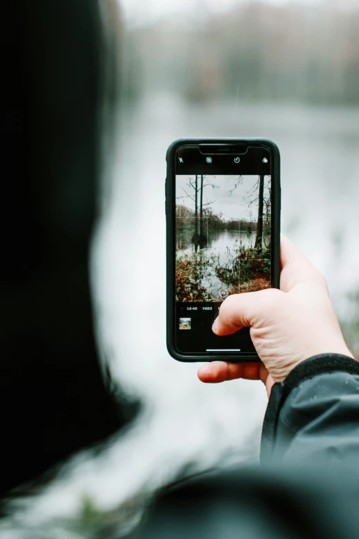 a person holding a cell phone with their picture taken