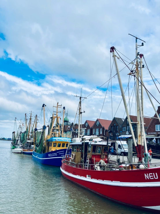 boats are lined up in a marina near the buildings