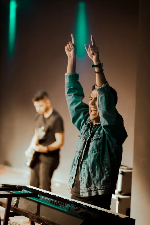 woman standing in the middle of a stage with hands up