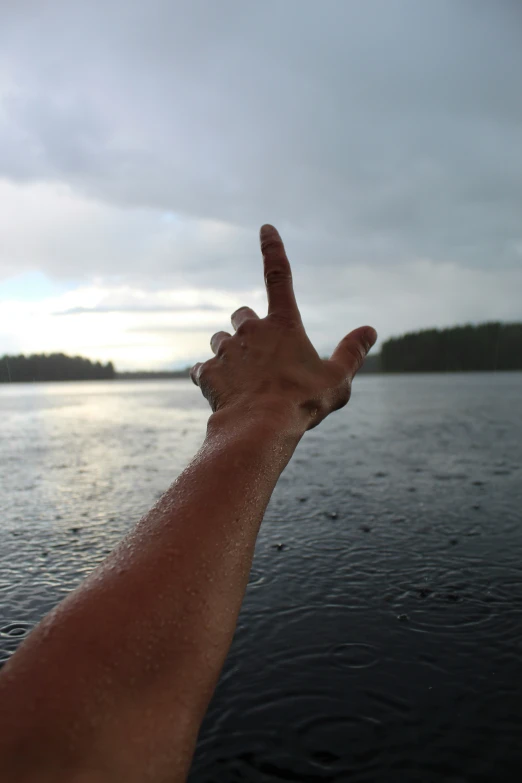 the person holds up their hand to touch the water