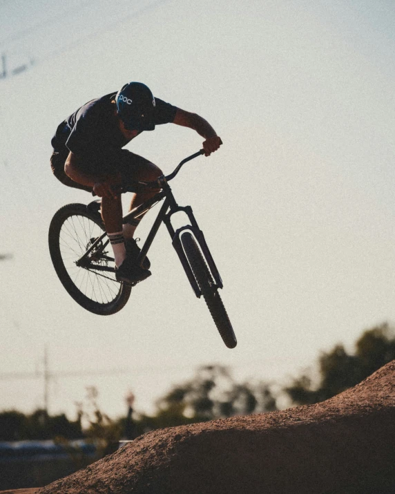 a man doing tricks on a bicycle during sunset