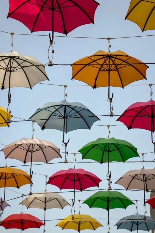 many umbrellas are floating in the sky for shade