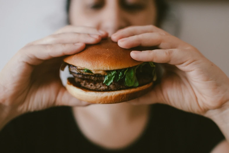 woman looking through a hole in her hamburger