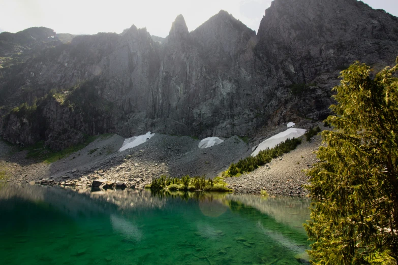 a lake is surrounded by mountains on a clear day