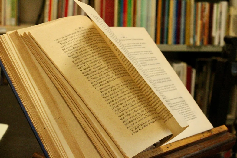 an open book in front of a bookshelf