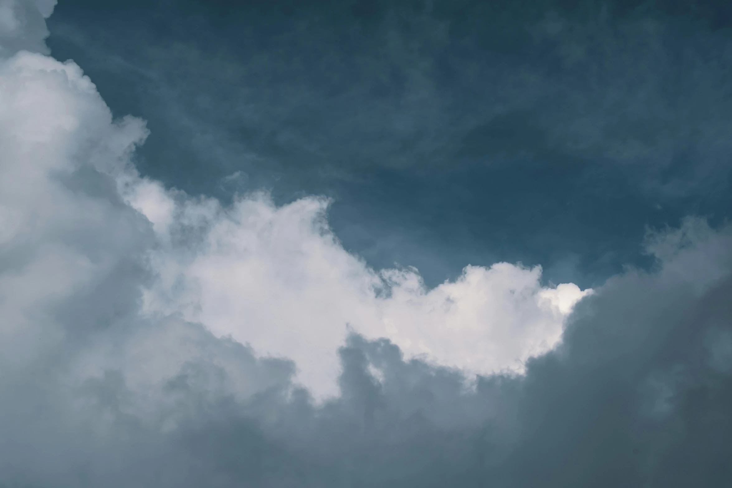 a plane is flying against the sky with many clouds