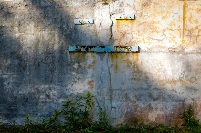 an old wall with a rusty, run down stop light hanging off of it