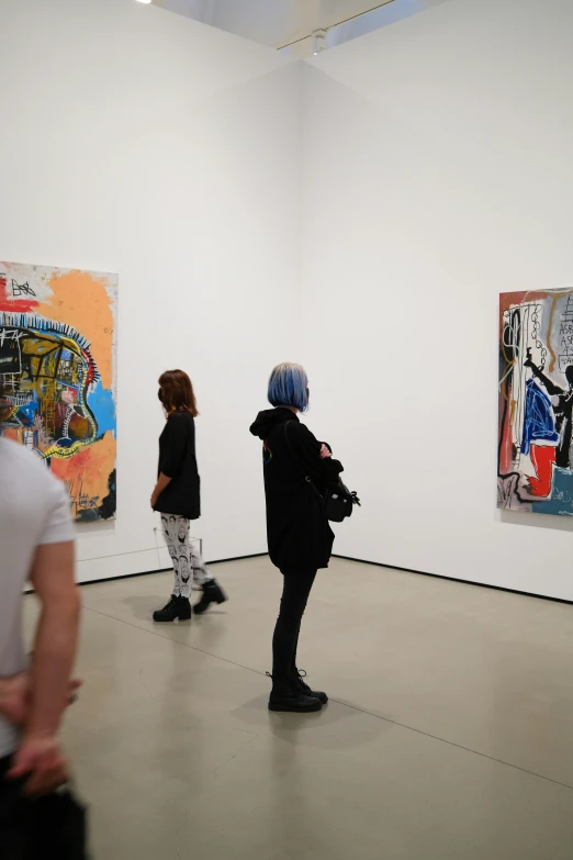 people looking at paintings in a room