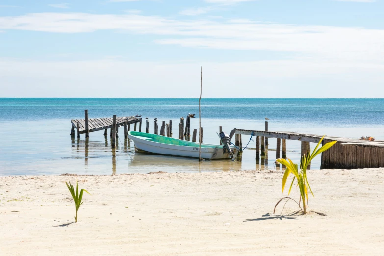 the boat is parked near the wooden pier on the water