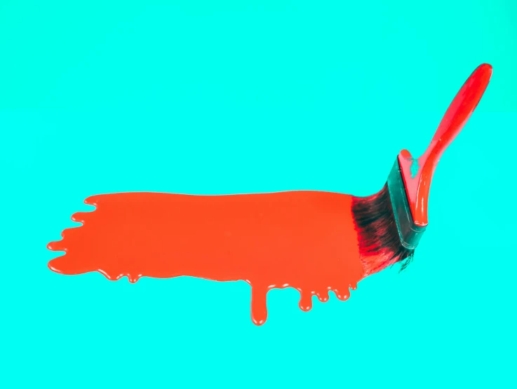 an orange paint covered brush with brown and red streaks