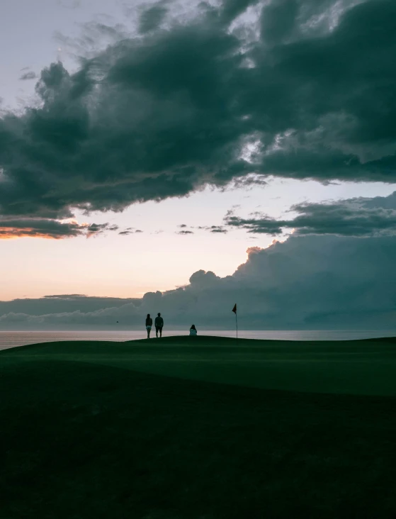 people are walking along the beach on an overcast day