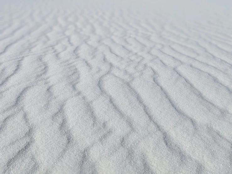 the sand is covered in snow in an empty area