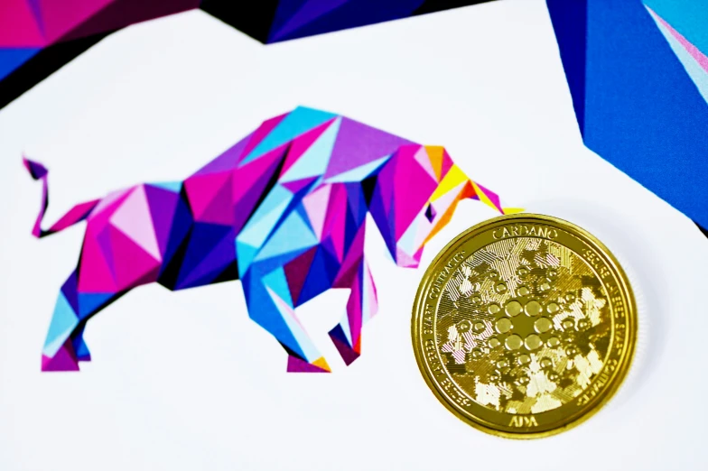 there is a small paper rhino next to a tiny gold coin