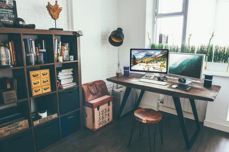 a home office with large windows, a wood table and a wooden chair