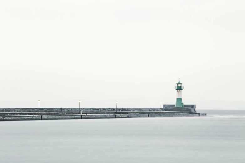 a small lighthouse at the end of a long pier