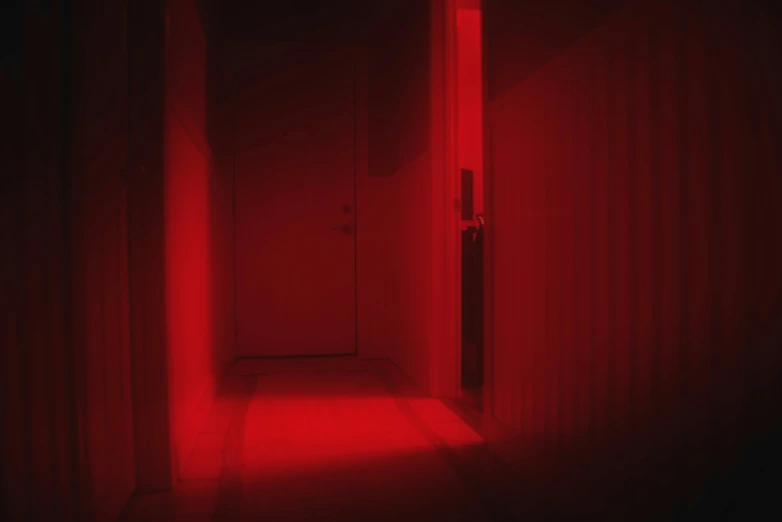 a hallway with red lighting coming from the end