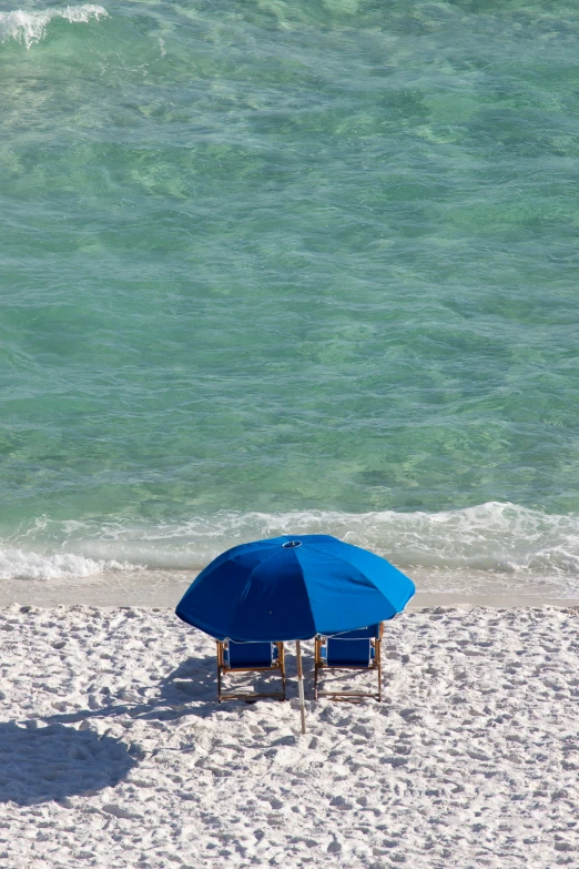 a blue umbrella that is next to a chair