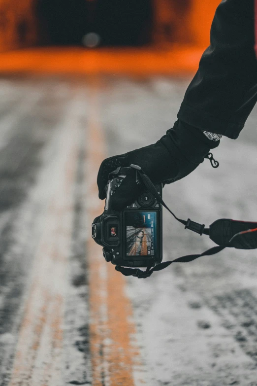 a camera being held in the air with the front end of the hand