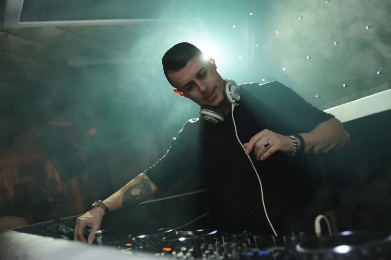 a dj spins his turn with earbuds on