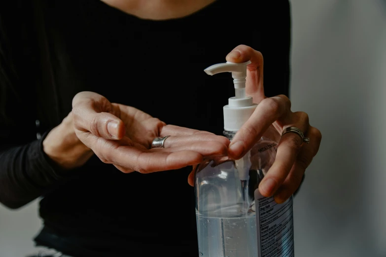 a woman is cleaning her hands with sanitizers