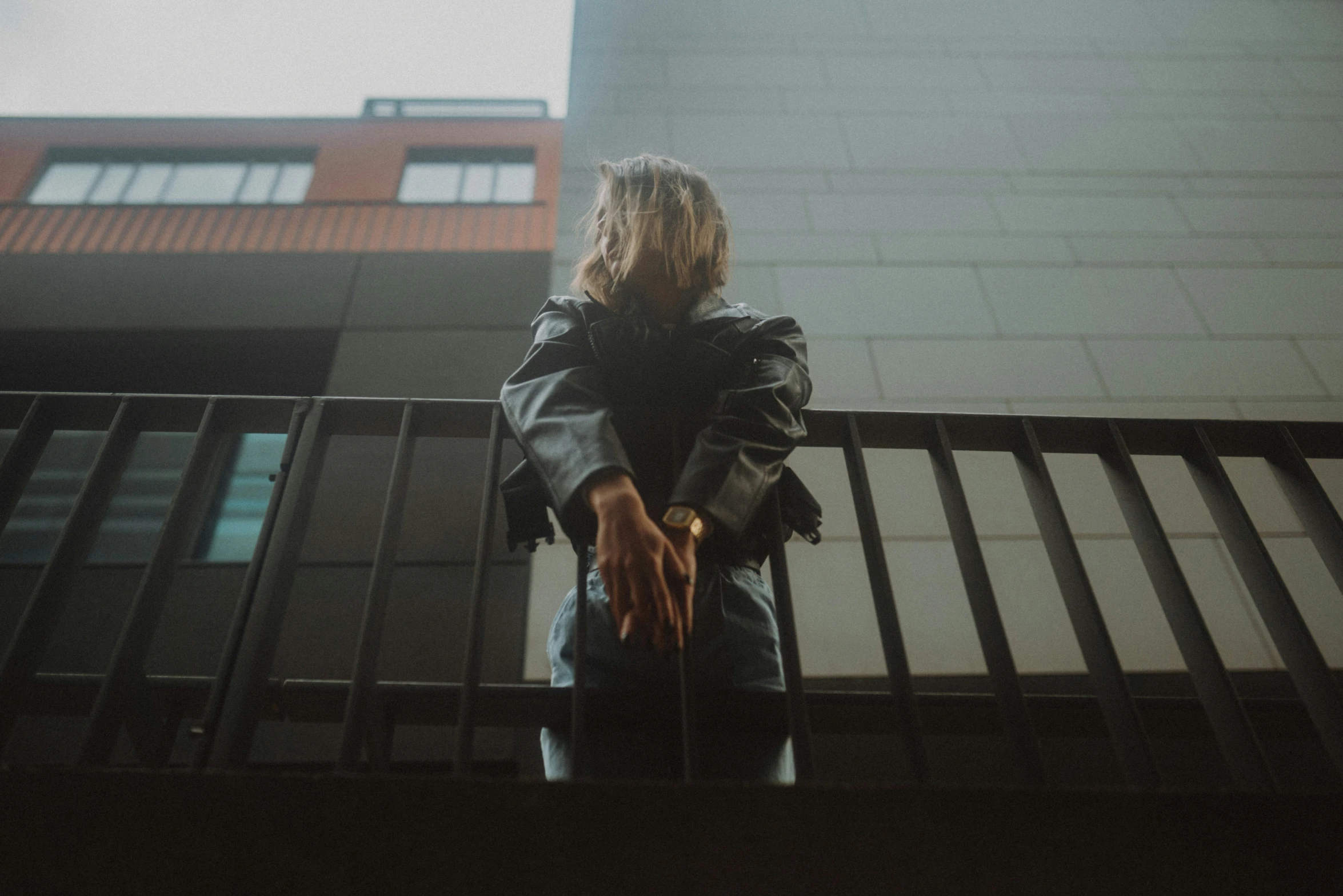 someone standing on a balcony holding the hand of someone