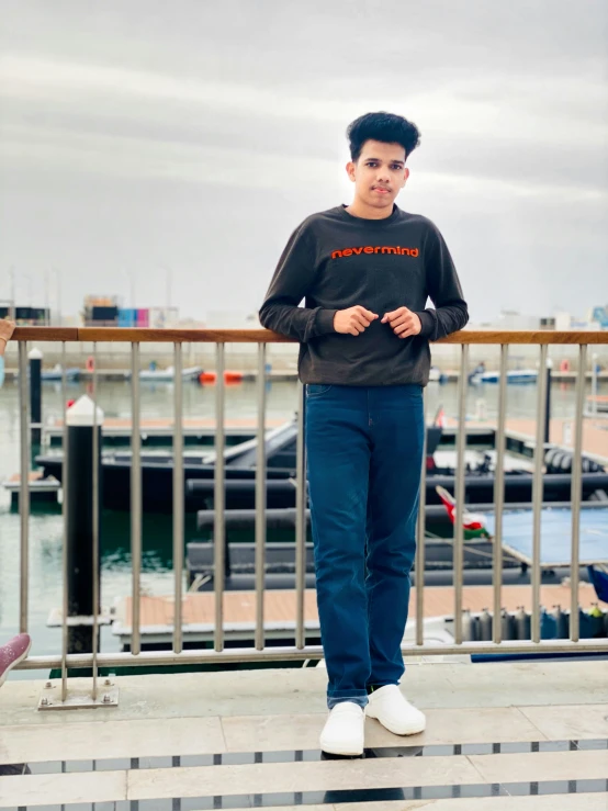 a man leaning against a rail near a harbor