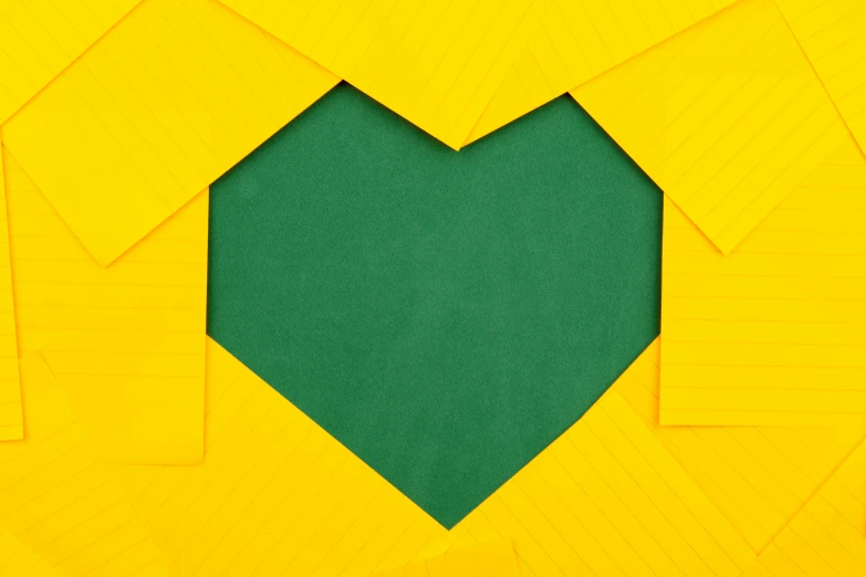 a green heart is cut in half on a yellow background