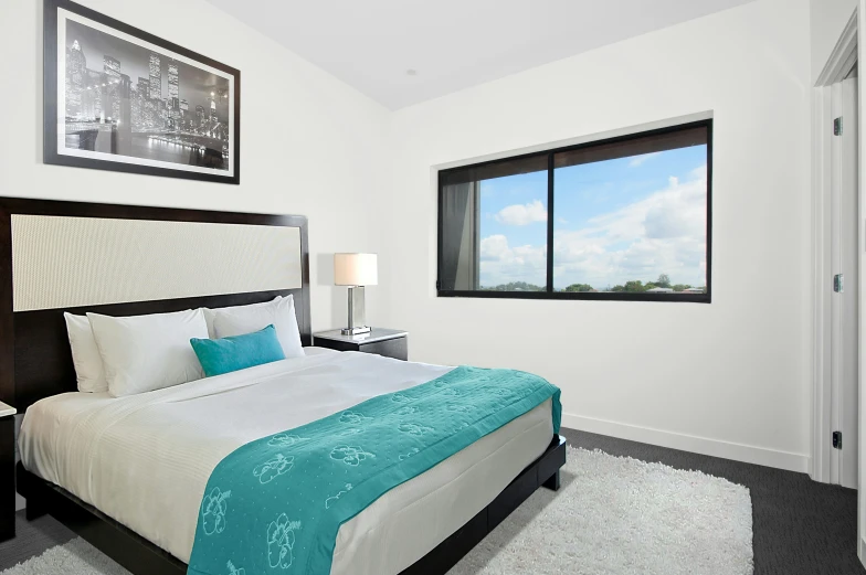 a bed room with a neatly made bed and two large windows